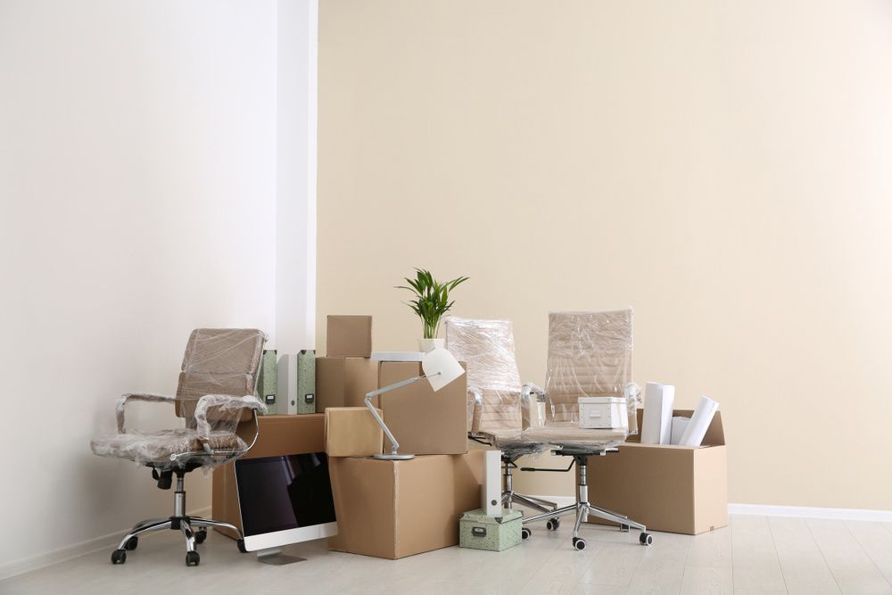 A Room Filled With Cardboard Boxes and Office Furniture — Davis Removals & Storage in Canberra, ACT