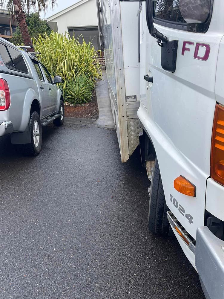 Two Cars Are Parked Next to Each Other on the Side of the Road — Davis Removals & Storage in Sydney, NSW
