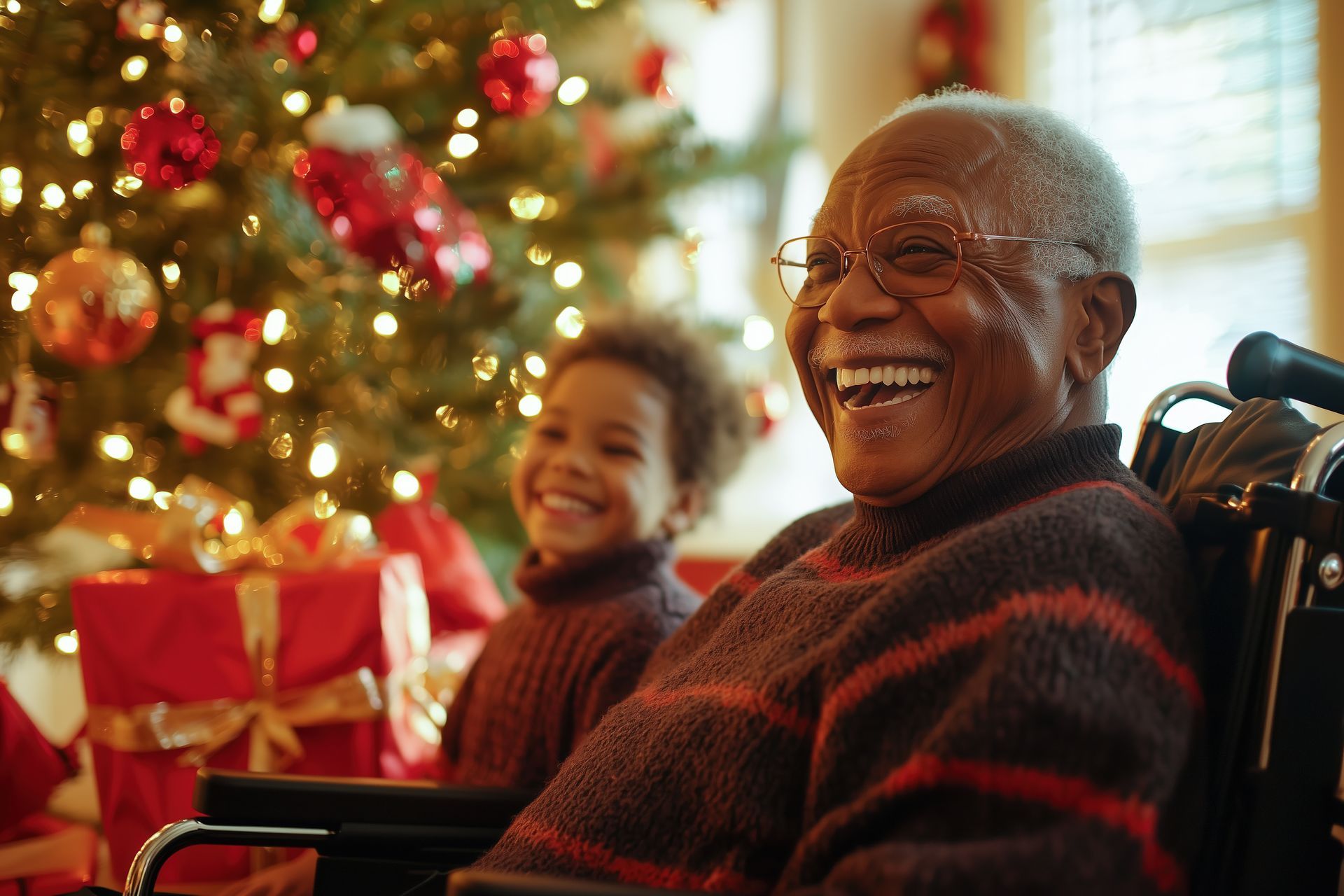 An elderly man in a wheelchair is sitting in front of a christmas tree.