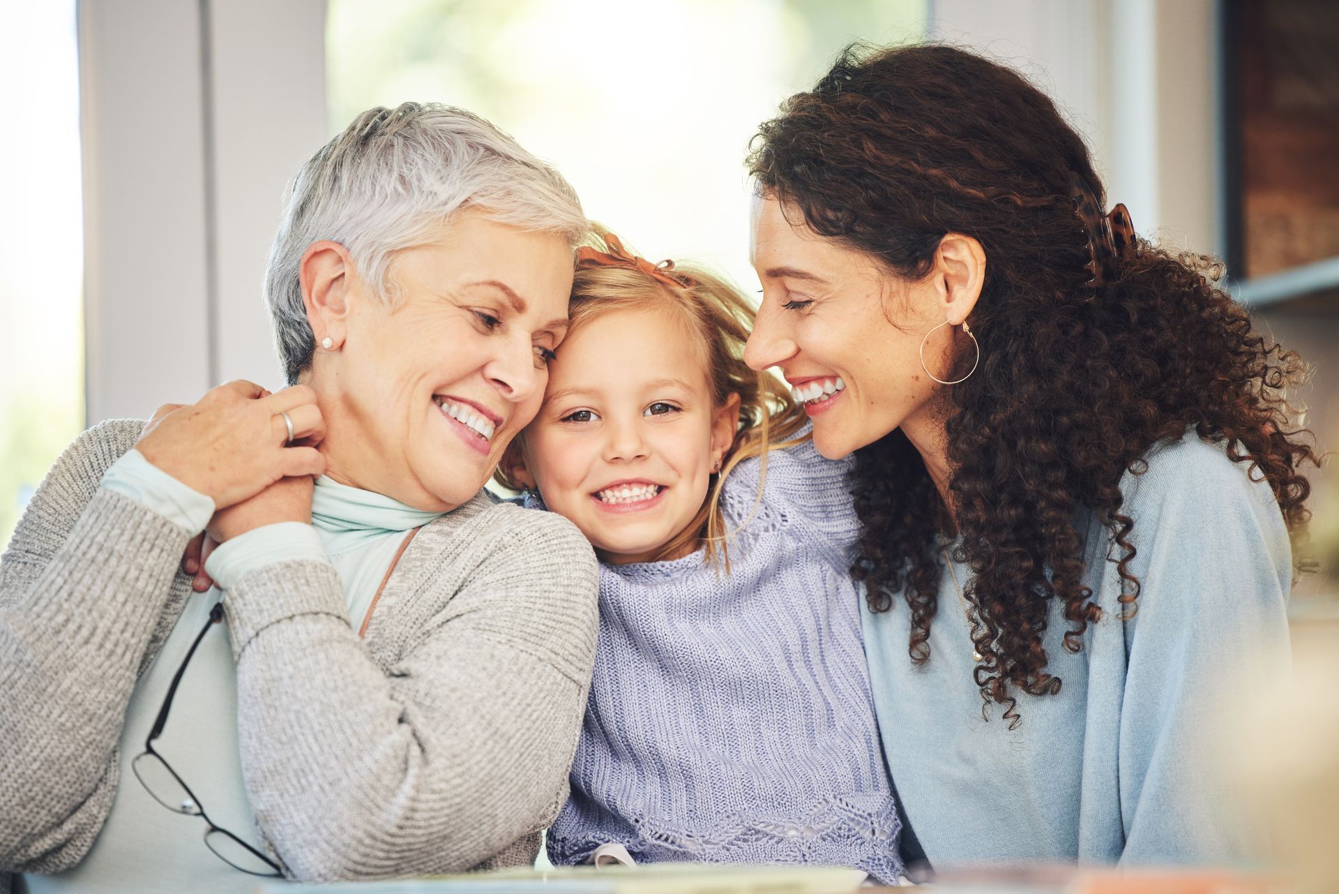 aging parent, daughter and child smiling together