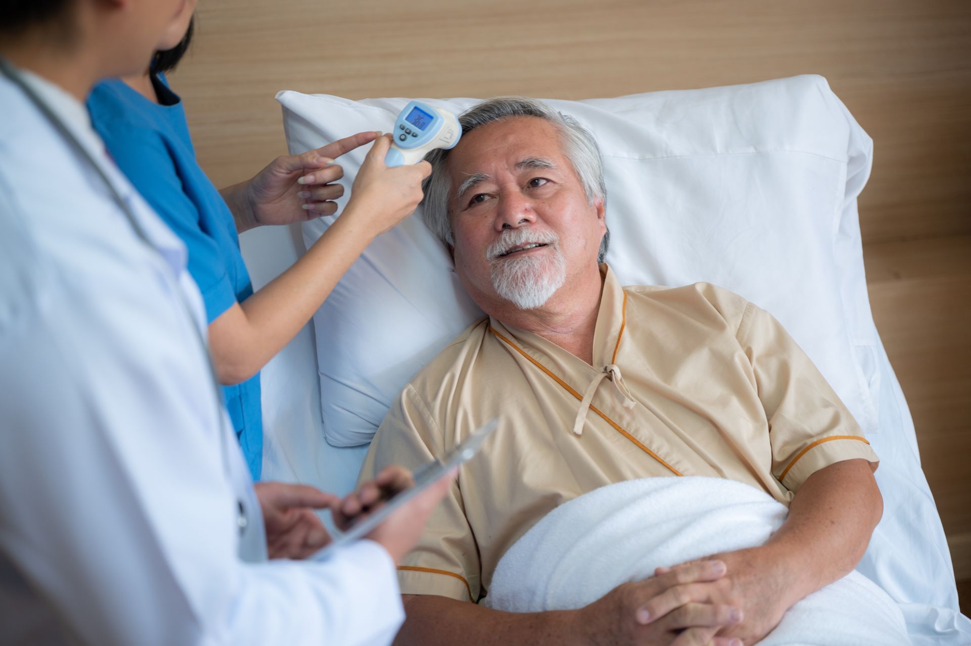 A caregiver is taking a patient 's temperature after surgery