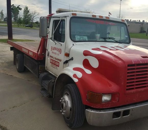 A Red And White Tow Truck Is Parked On The Side Of The Road