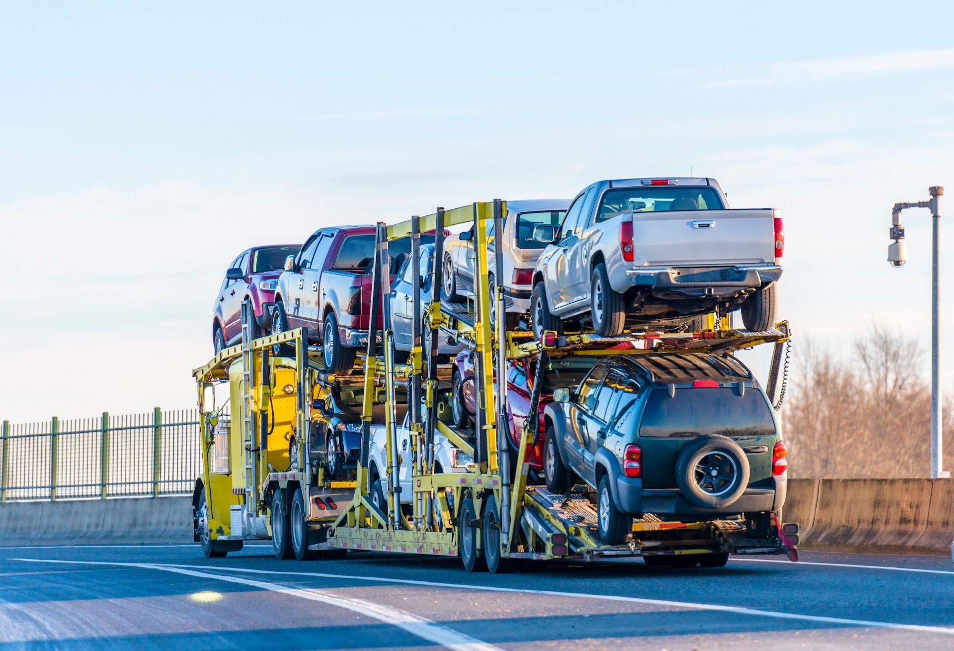 A truck is carrying a bunch of cars on a highway.