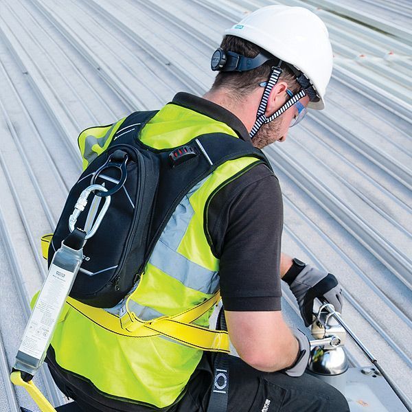 Person in a hard hat climbing a ladder inside a large, cylindrical structure.