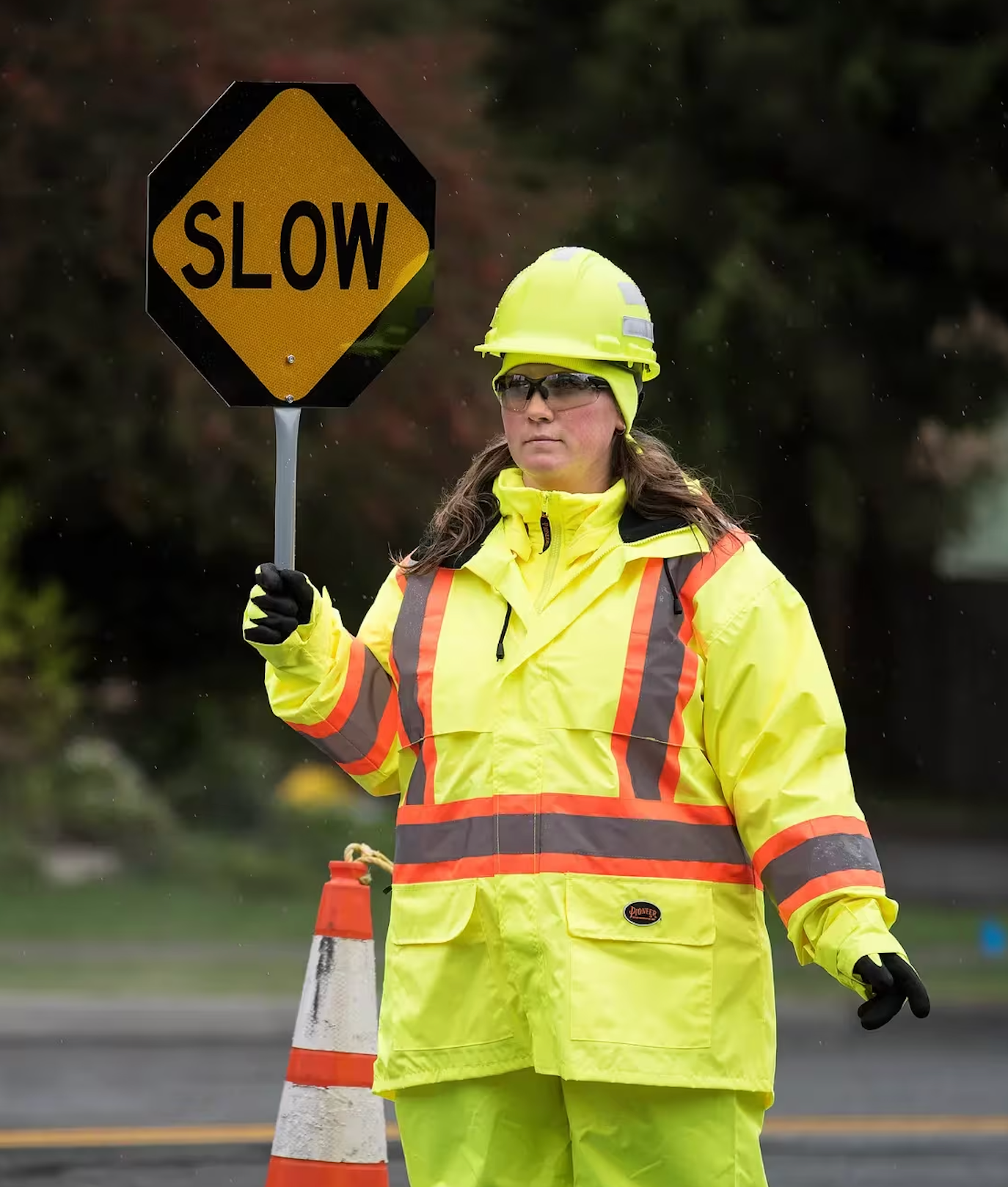 Person in high-visibility yellow jacket holding a