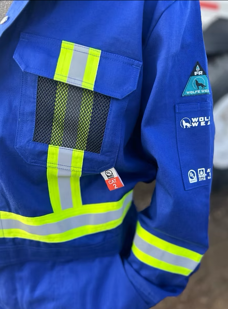 Blue work coverall with reflective yellow stripes, a mesh pocket, and patches.