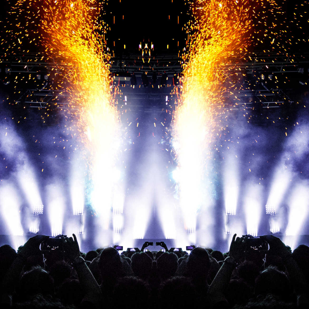 A crowd of people watching a fireworks display at a concert