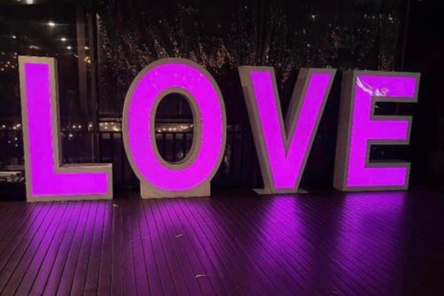 A large love sign is lit up in a room.