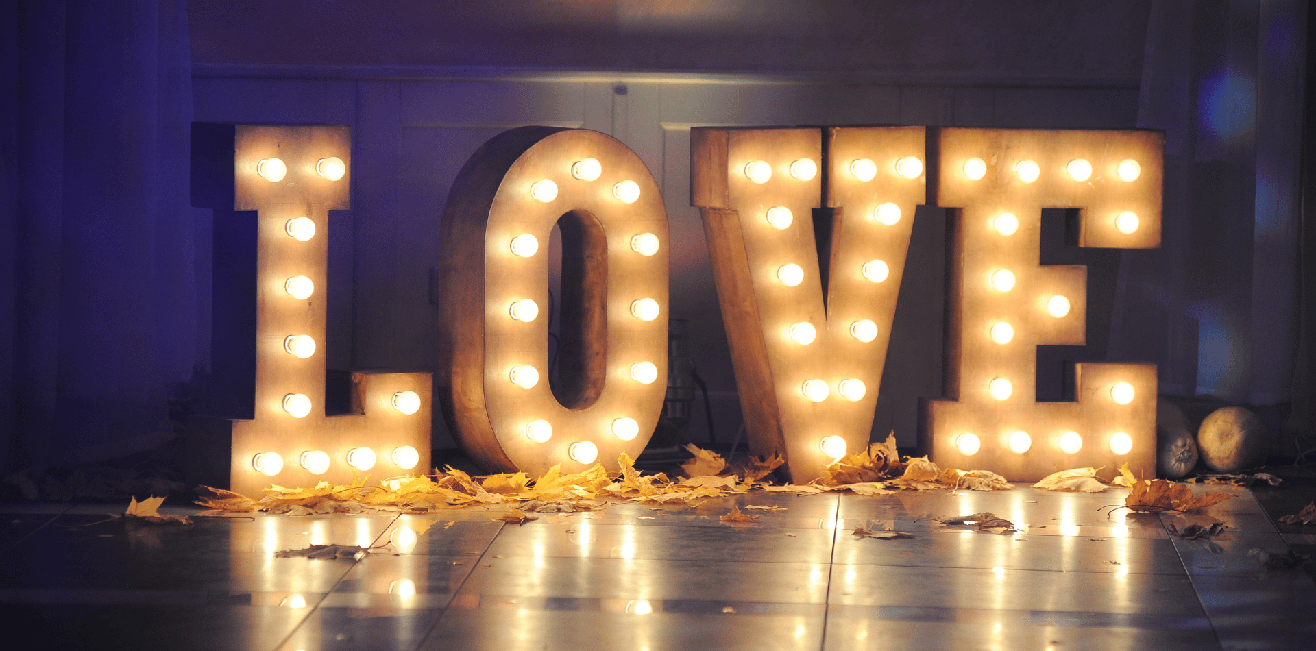 The word love is lit up with candles on the floor.