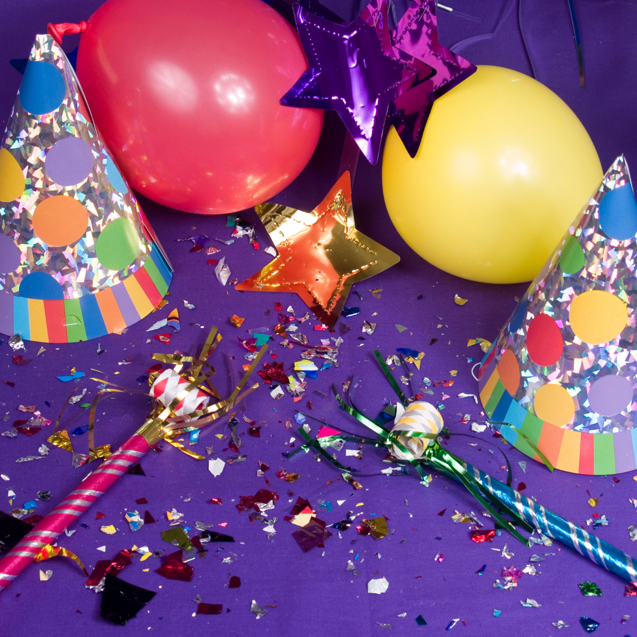 Balloons and party hats on a purple background