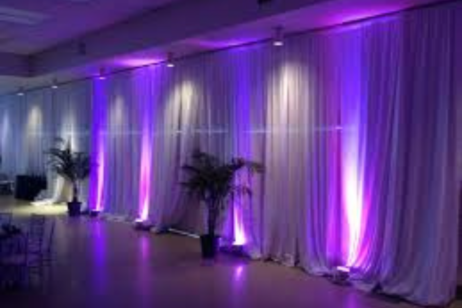 A room with white curtains and purple lights on the wall.