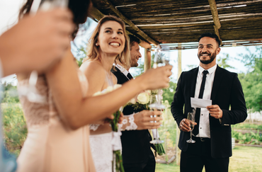 A bride and groom are dancing in front of fireworks at their wedding reception.