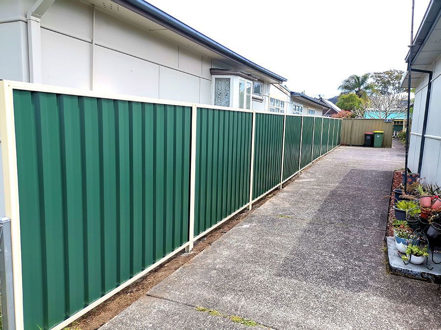 A Green Fence Along a Sidewalk Next to a House — WeFence in Lisarow, NSW