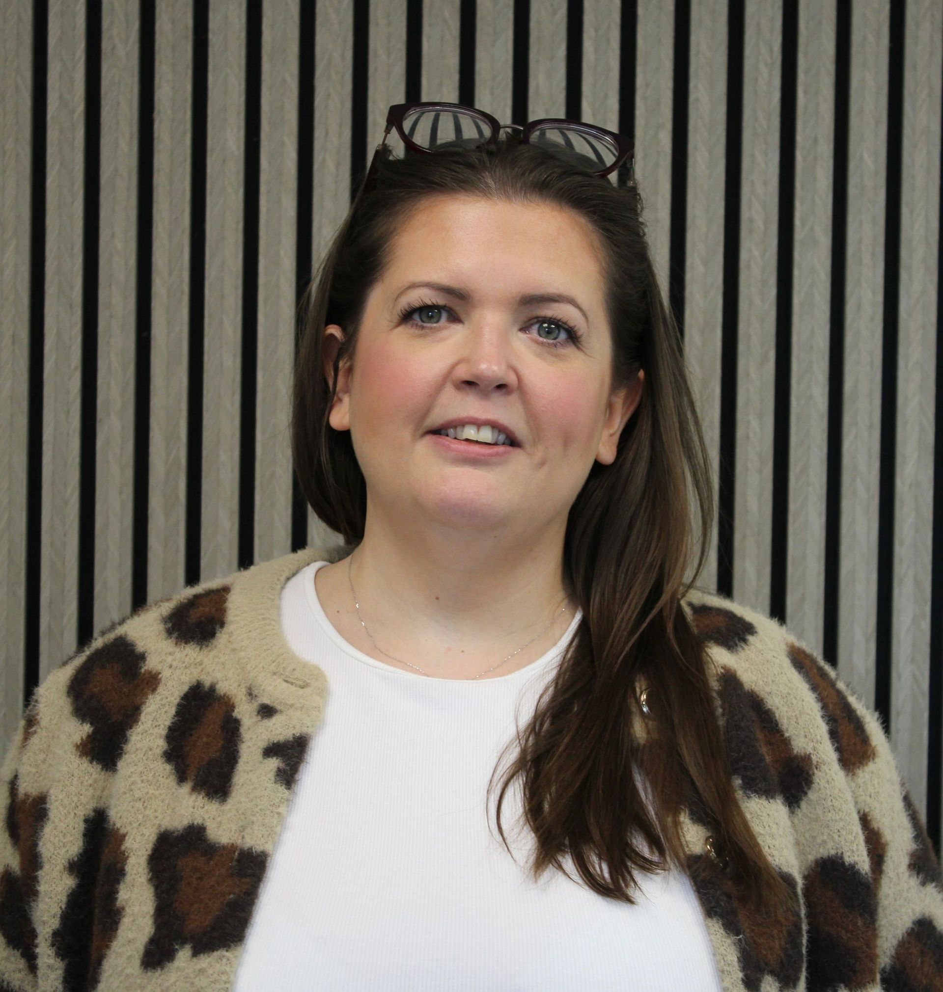 Purple abstract figure with arms raised, atop a triangular shape; a circle represents the head.