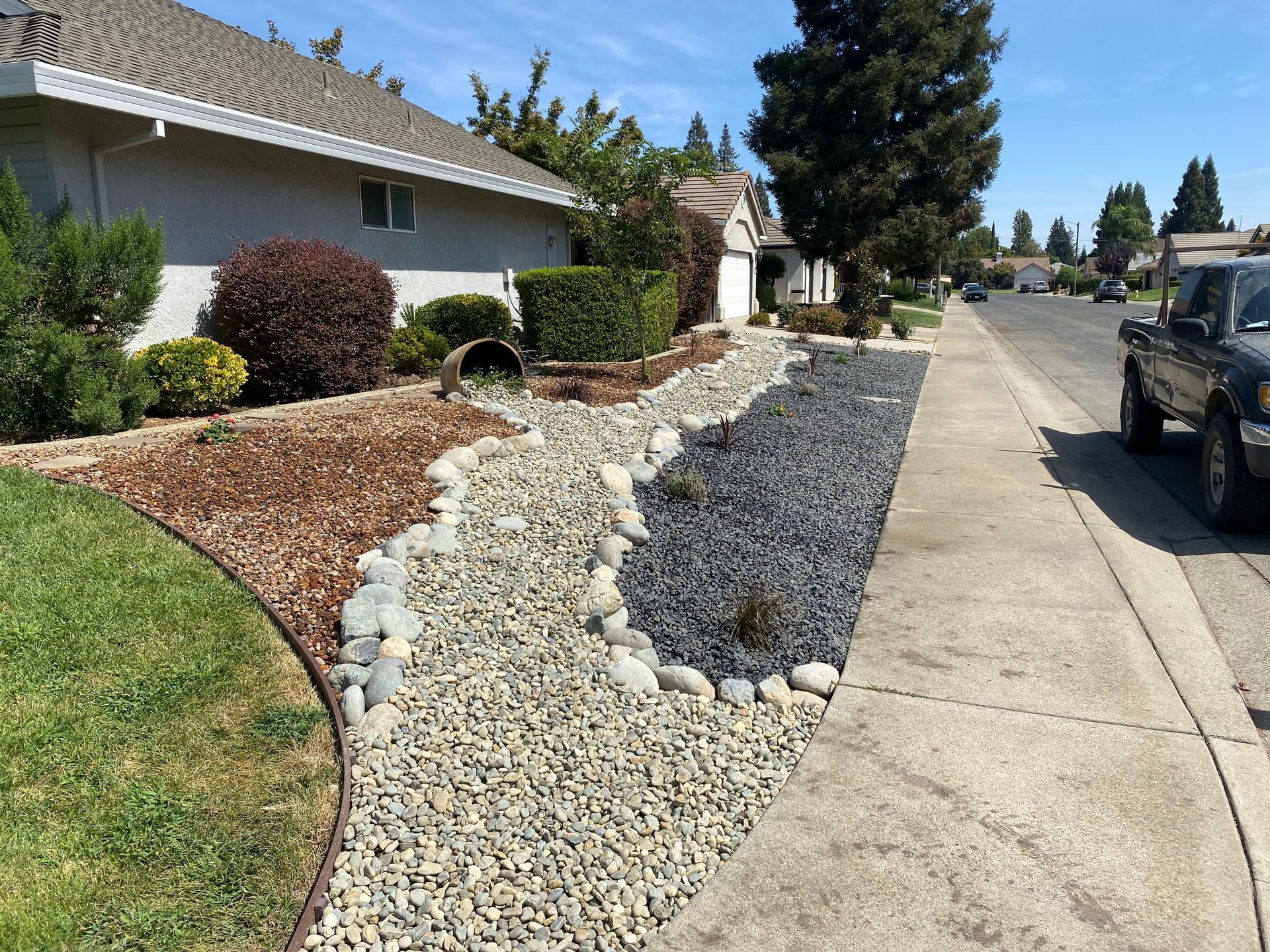 A truck is parked on the side of the road in front of a house.