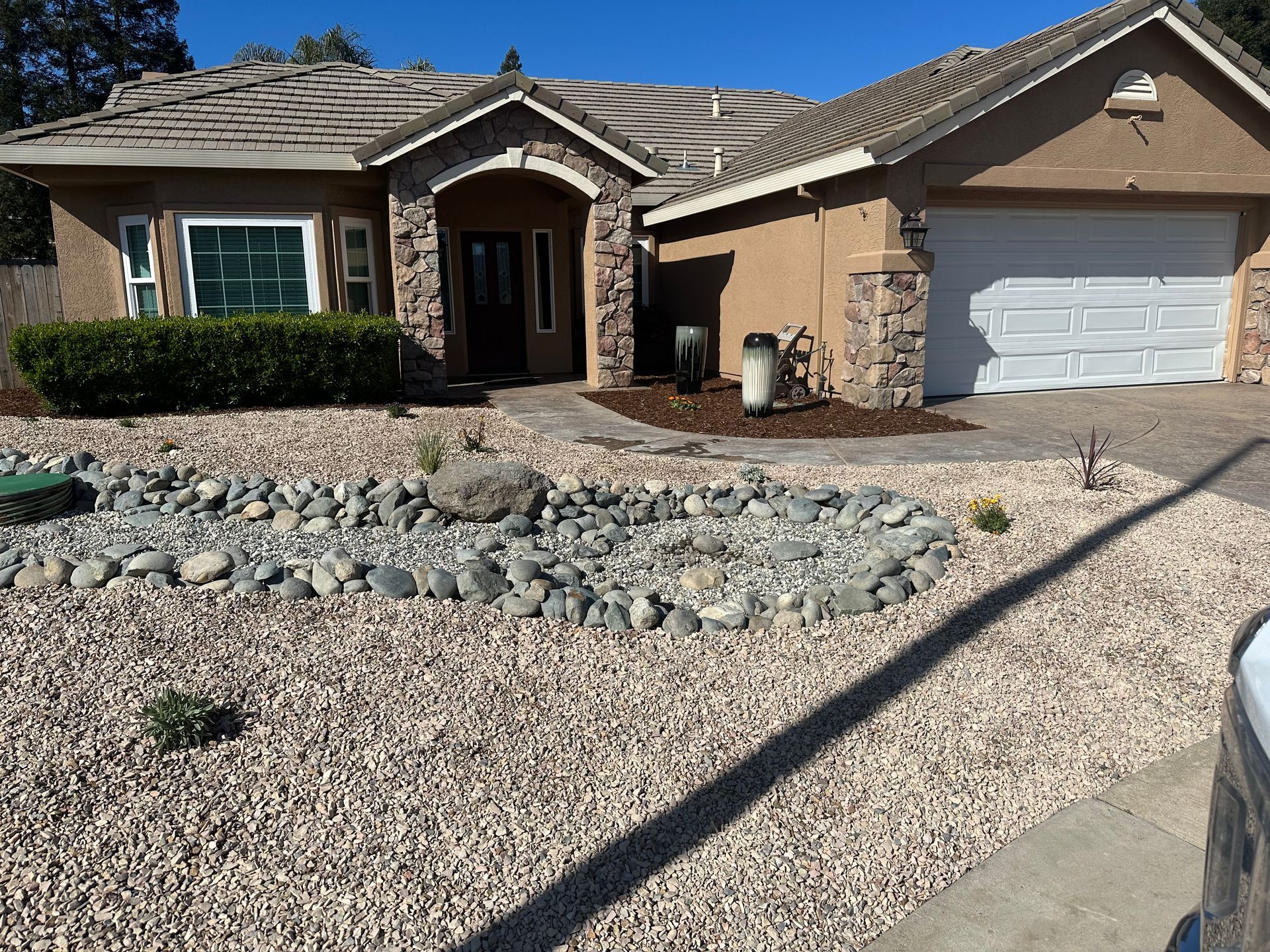 A house with a garage and gravel in front of it