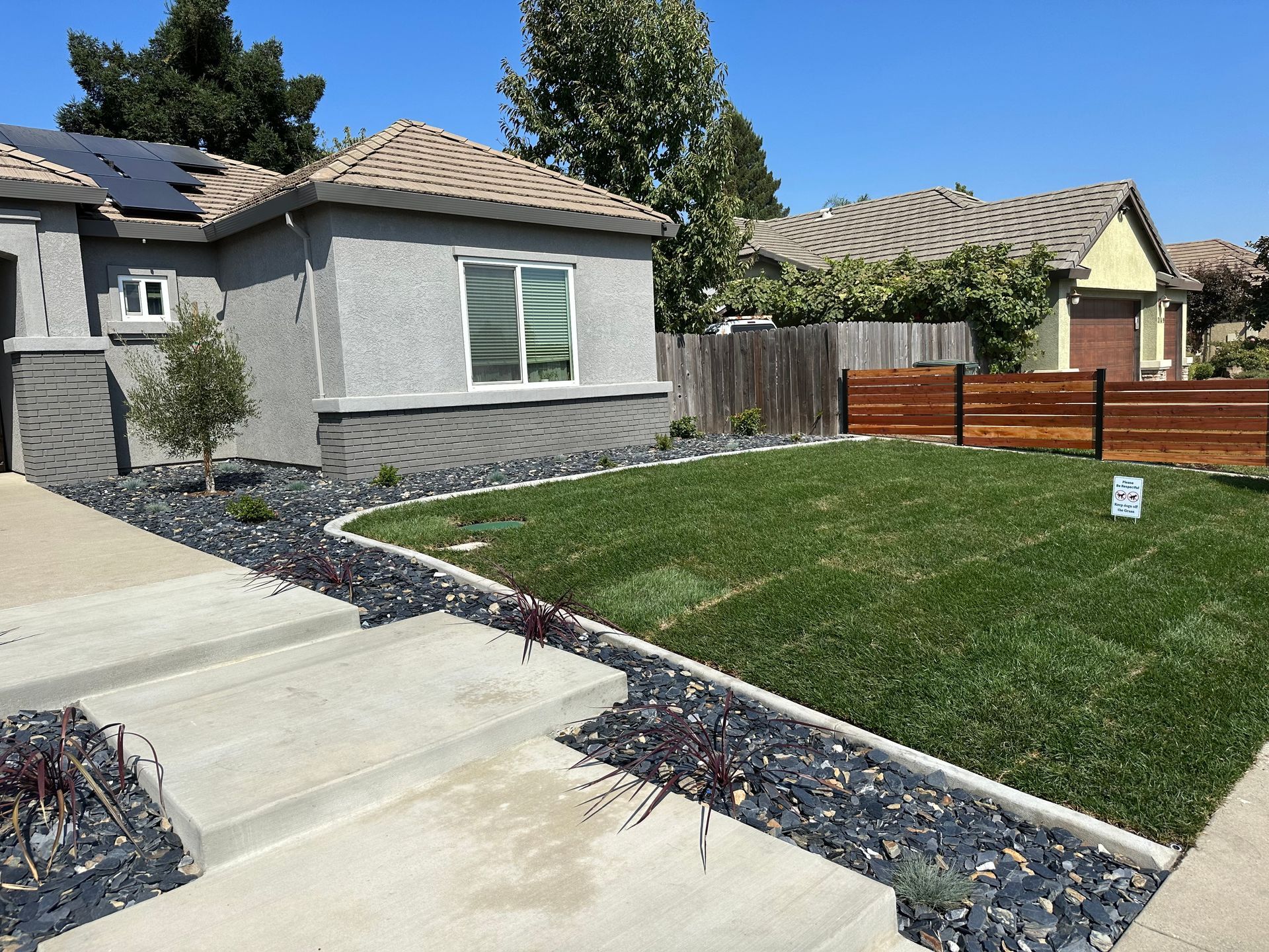 A house with a fence and a lawn in front of it
