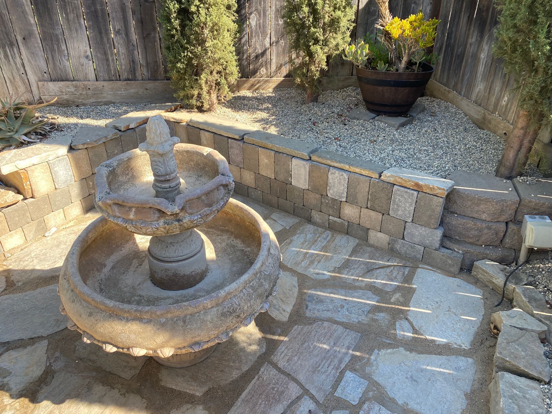 There is a fountain in the middle of the patio.