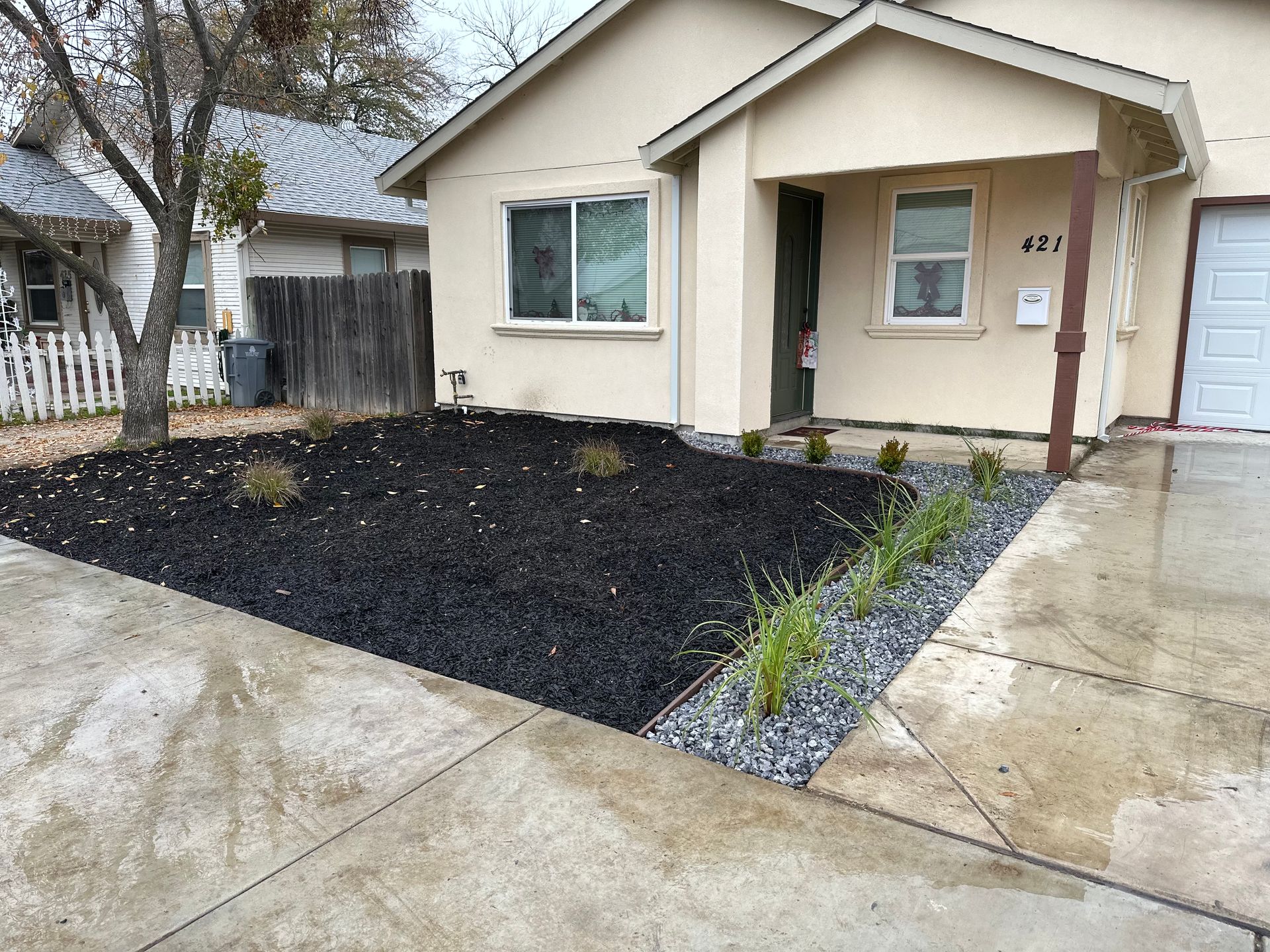 A house with a lot of black mulch in front of it