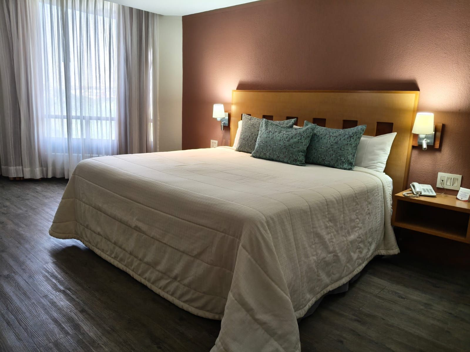 Una habitación de hotel con una cama king size impecablemente hecha