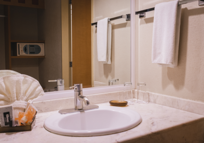 Un lavabo y grifo blancos sobre una encimera de mármol