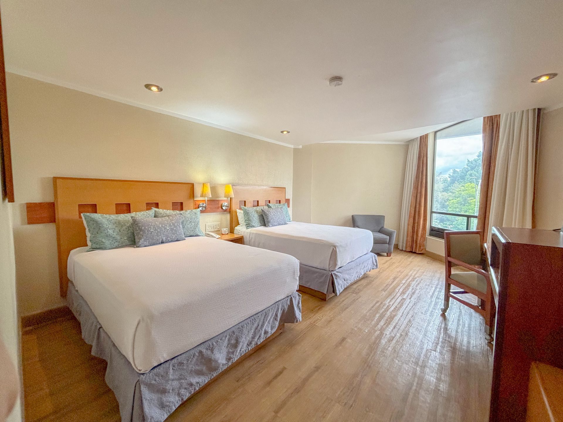 Una habitación de hotel luminosa con dos camas tamaño queen