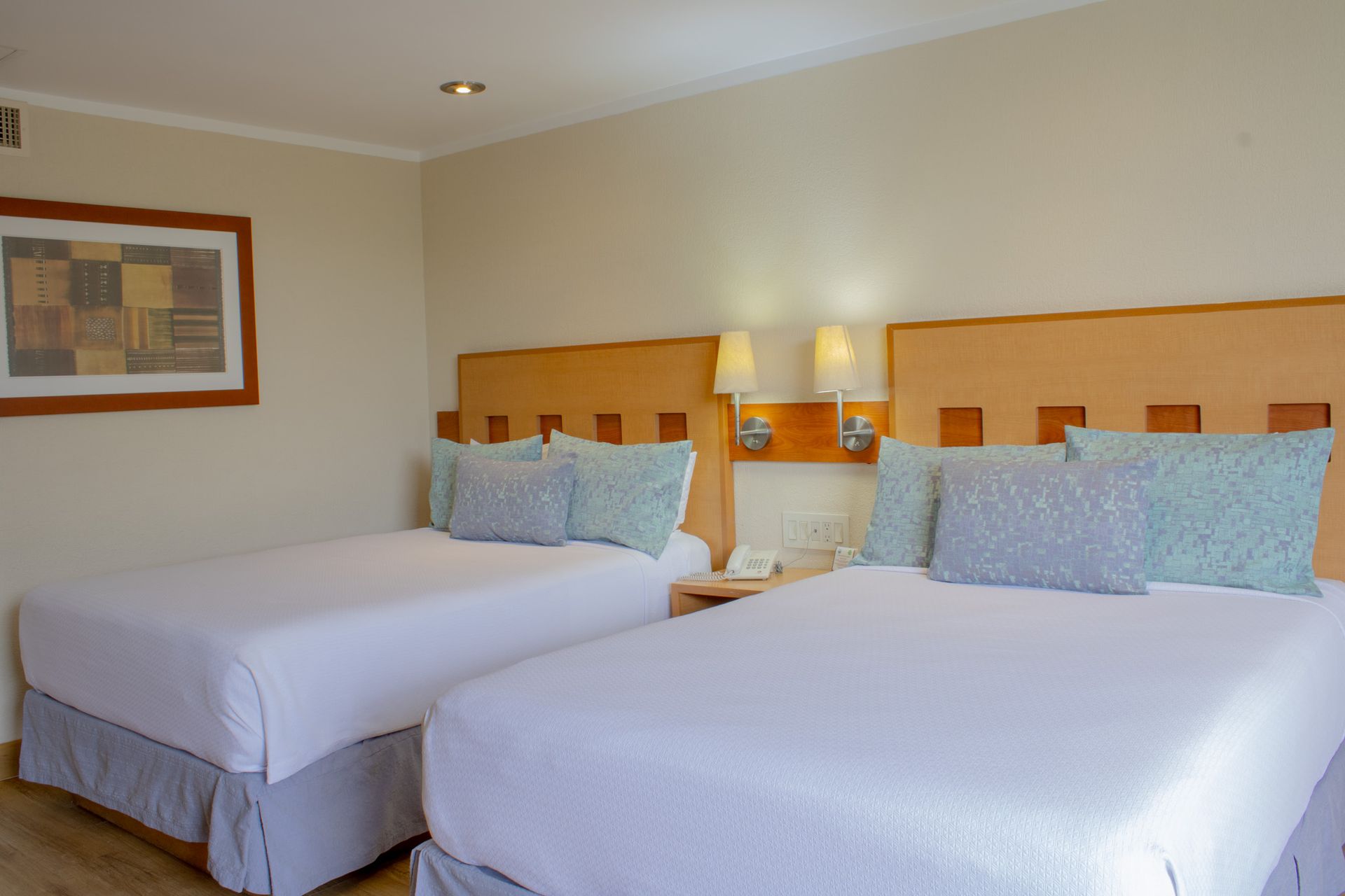 Una habitación de hotel con dos camas con sábanas blancas