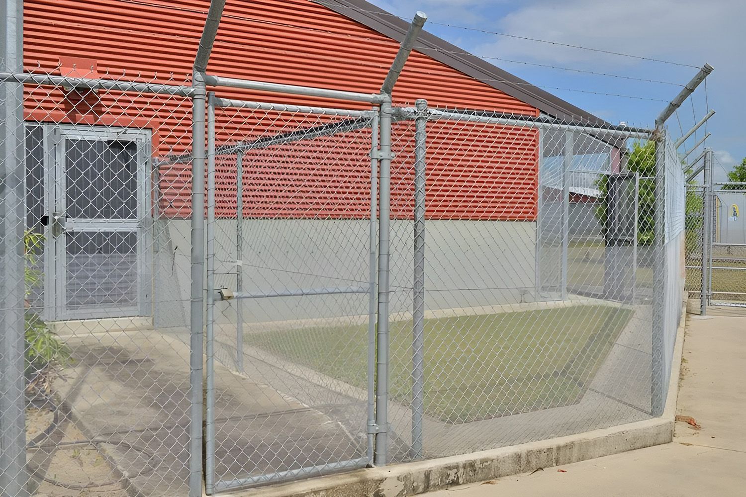 Chain Wire Fencing Surrounding A Brick Building
