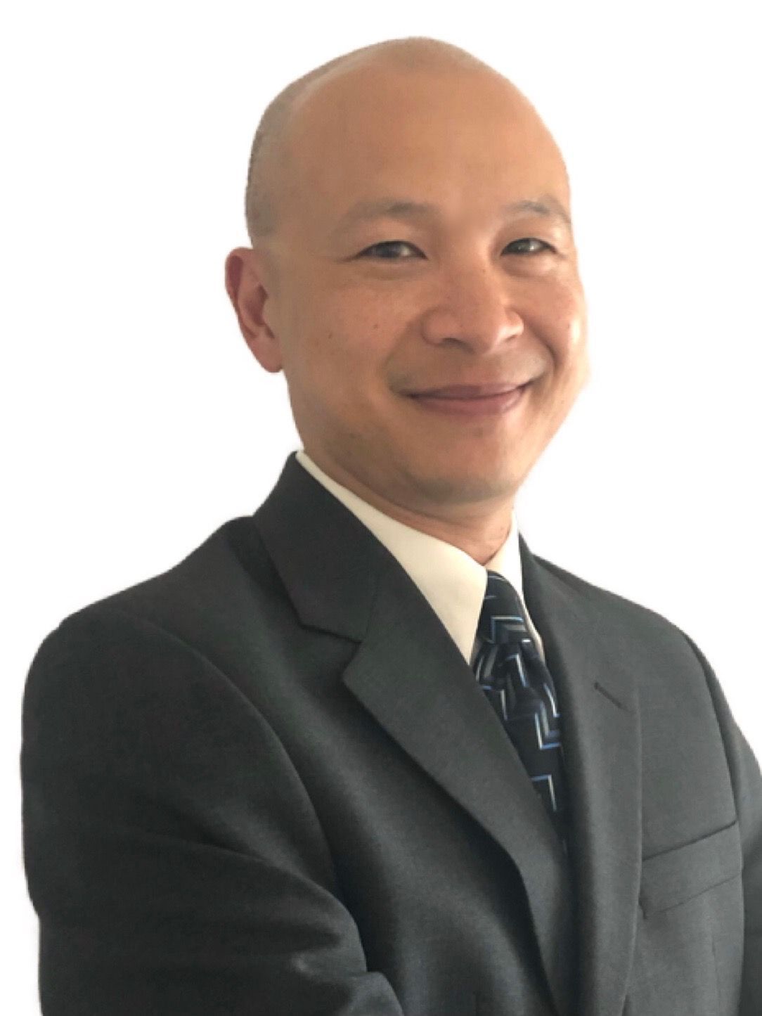 A woman is sitting at a desk with a laptop and a vase of flowers.