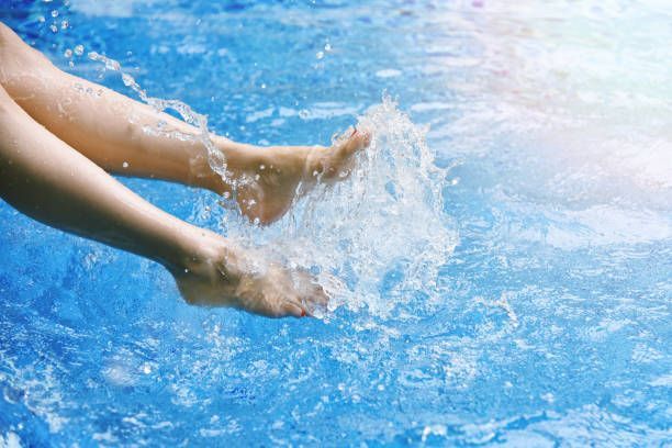 Happy girl splashing water, maintained by Environmental Air Systems, Pool Heater Repair Company