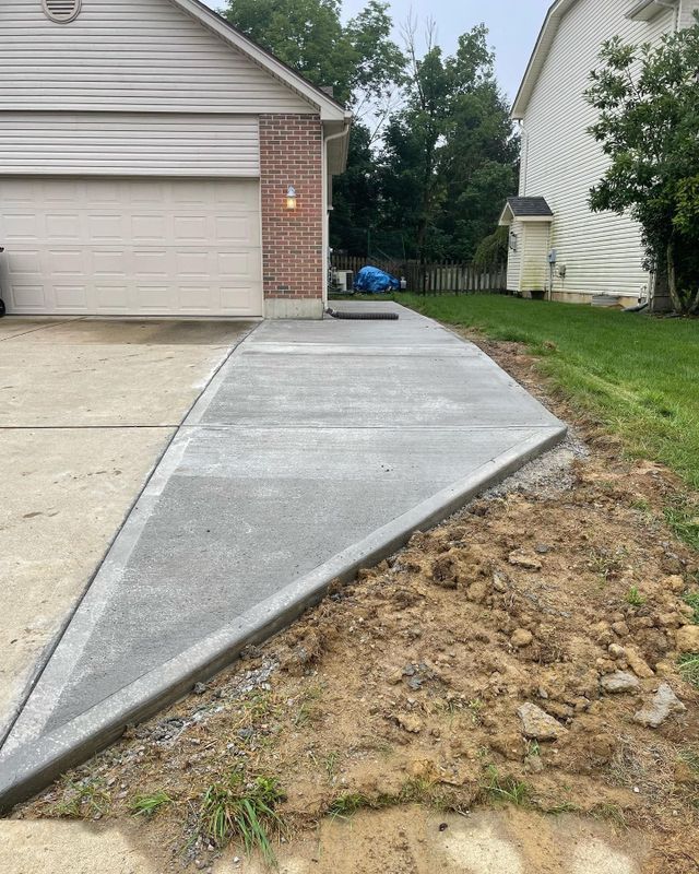 A Concrete Driveway Is Being Built In Front Of A House — Chesterton, IN — Claycor Construction