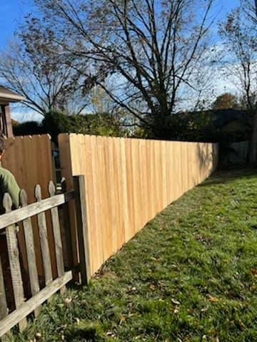 A Man Is Standing Next To A Wooden Fence — Chesterton, IN — Claycor Construction