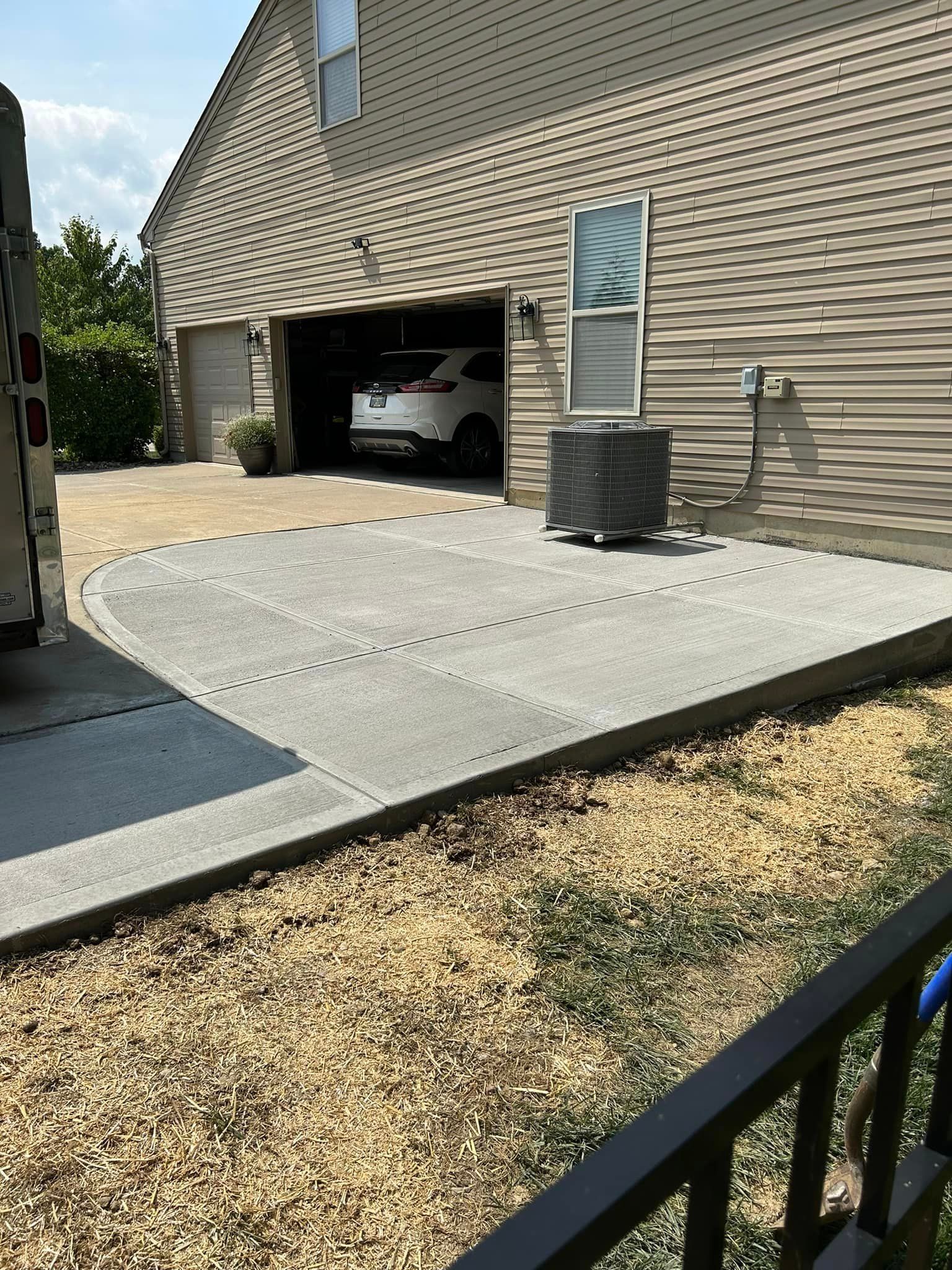 a car is parked in a garage next to a concrete driveway