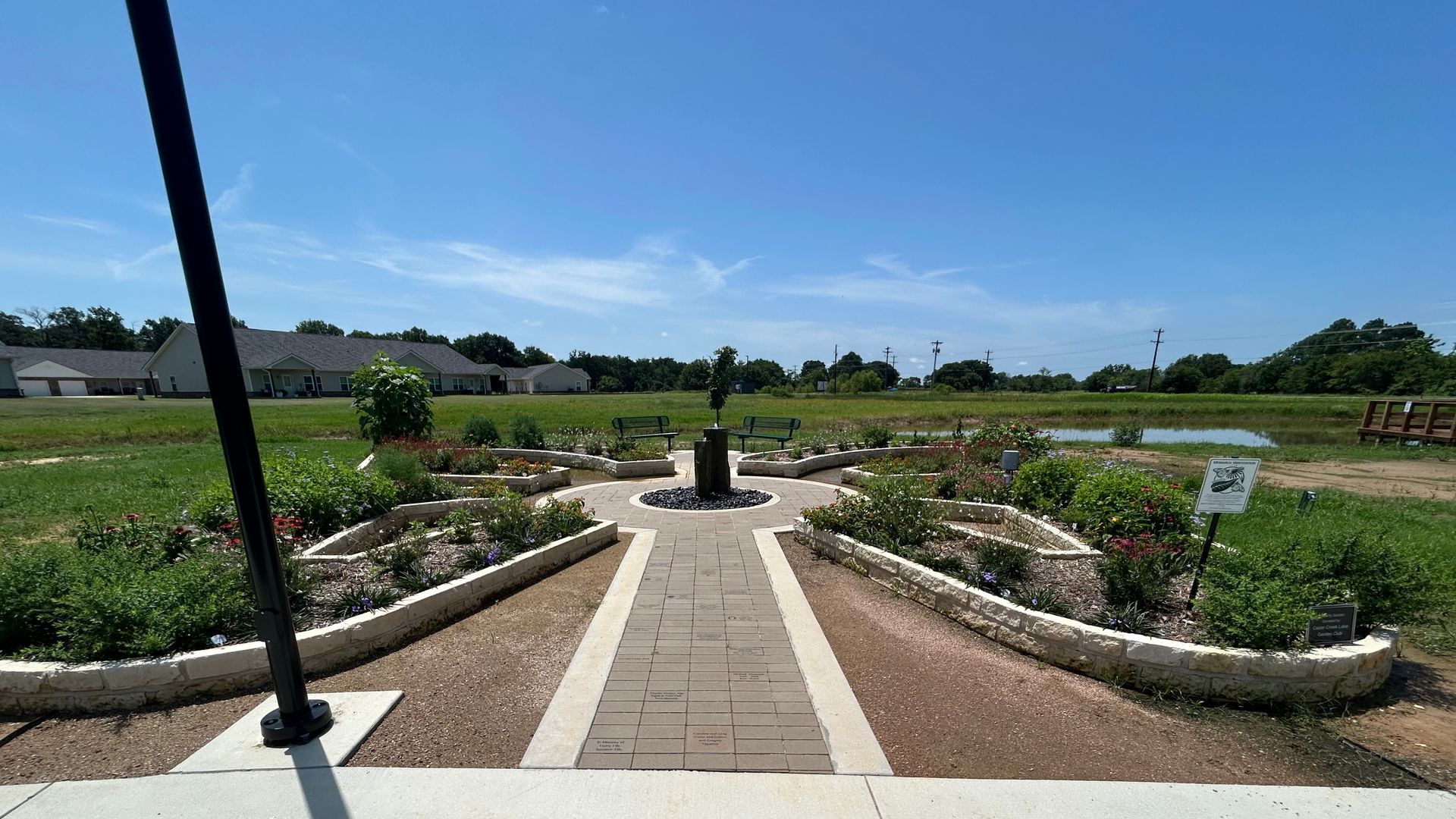 A brick walkway leading to a lush green field