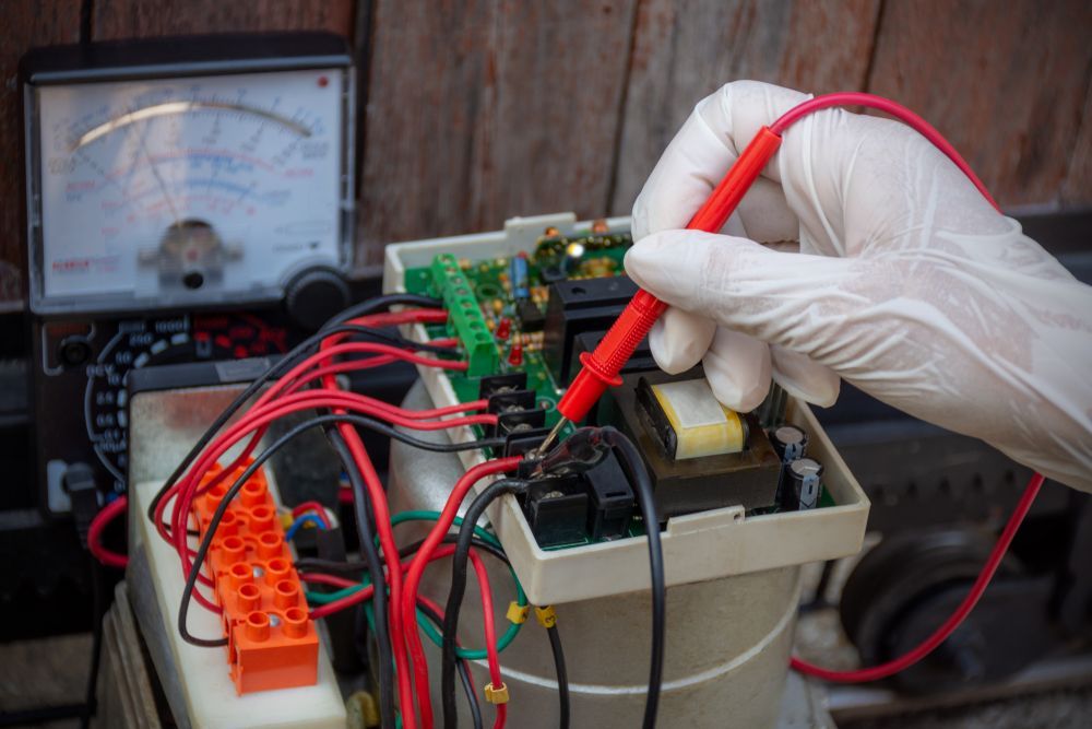 A Person is Using a Multimeter to Test a Circuit Board — Clifford Electrical in Ballina, NSW