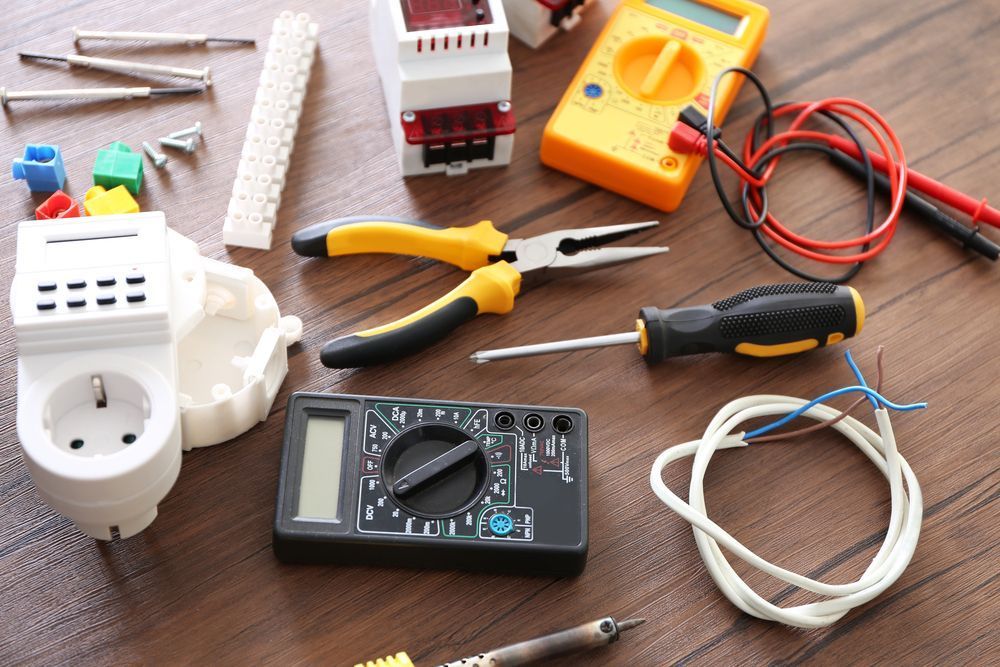 A Bunch of Electrical Tools Are on a Wooden Table — Clifford Electrical in Ballina, NSW