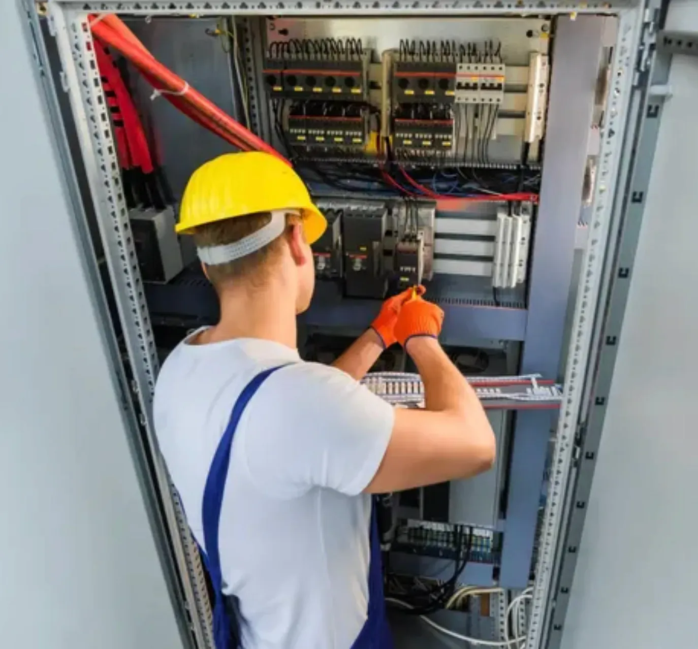 A Person is Using a Screwdriver on an Electrical Board  — Clifford Electrical in Ballina, NSW