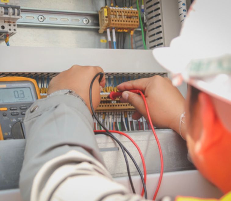 An Electrician is Working on a Circuit Board With a Multimeter — Clifford Electrical in Lennox Head, NSW