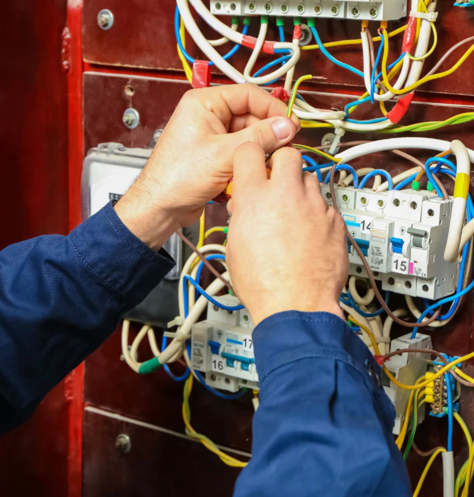 A Man Wearing a Hard Hat is Working on an Electrical Panel — Clifford Electrical in Ballina, NSW