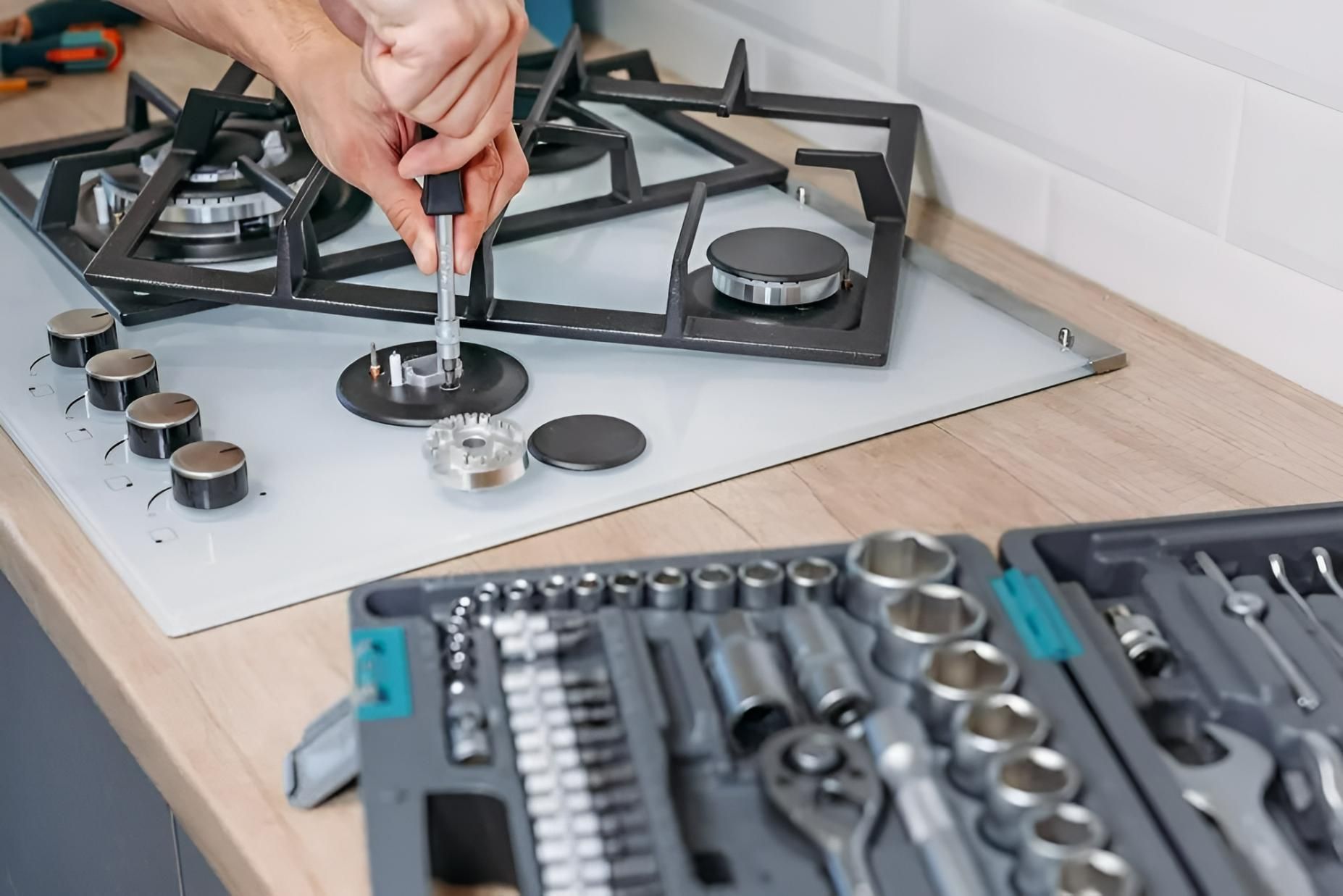 A Person is Fixing a Gas Stove With a Wrench — Clifford Electrical in Ballina, NSW