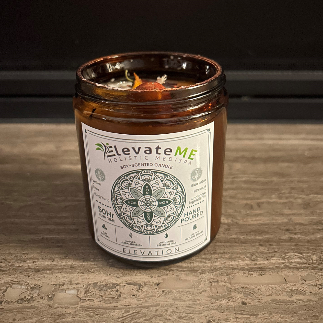 A candle in a jar with a label that says elevate me on it.