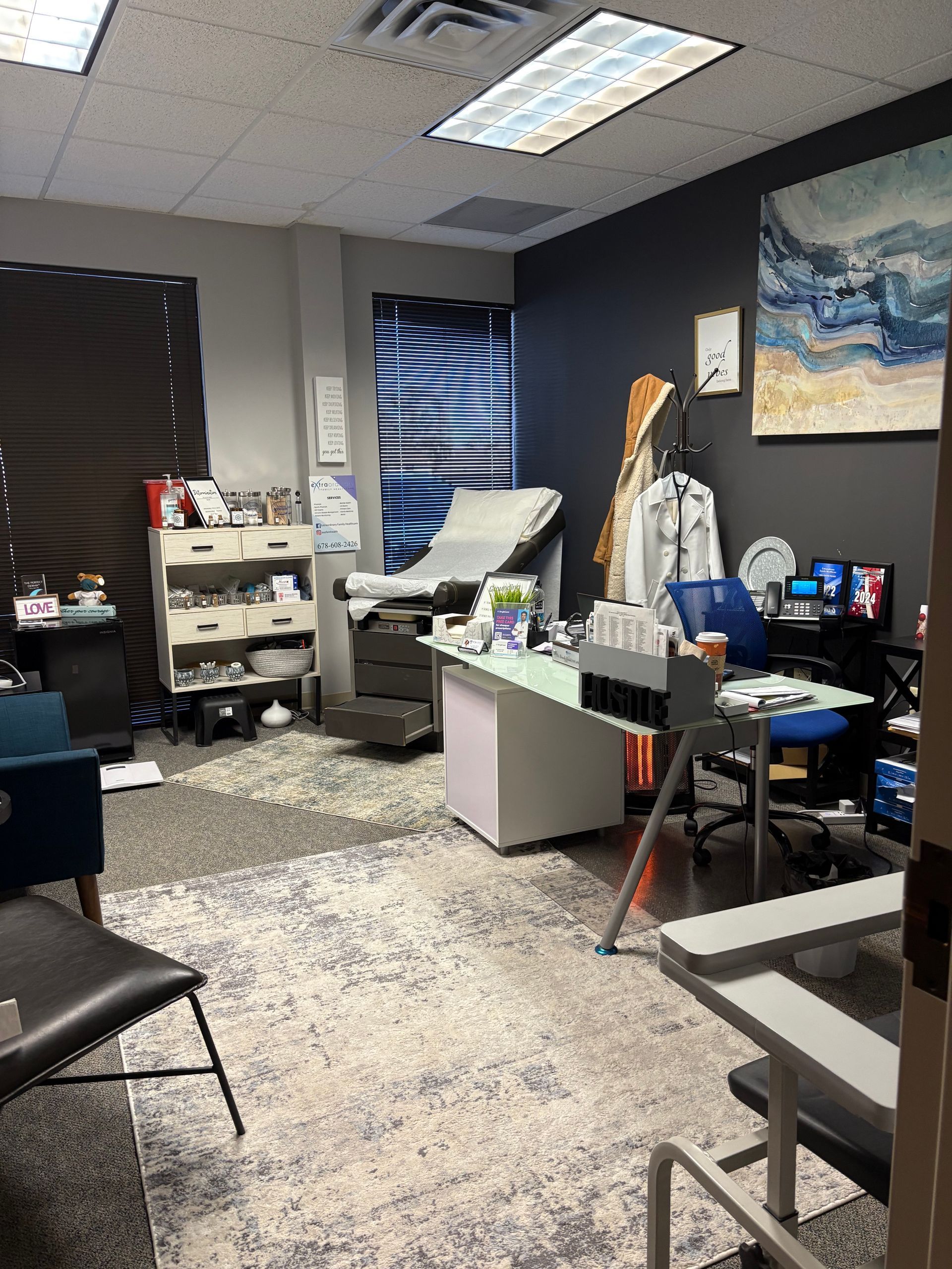 A room with a couch , desk , chairs and a painting on the wall.