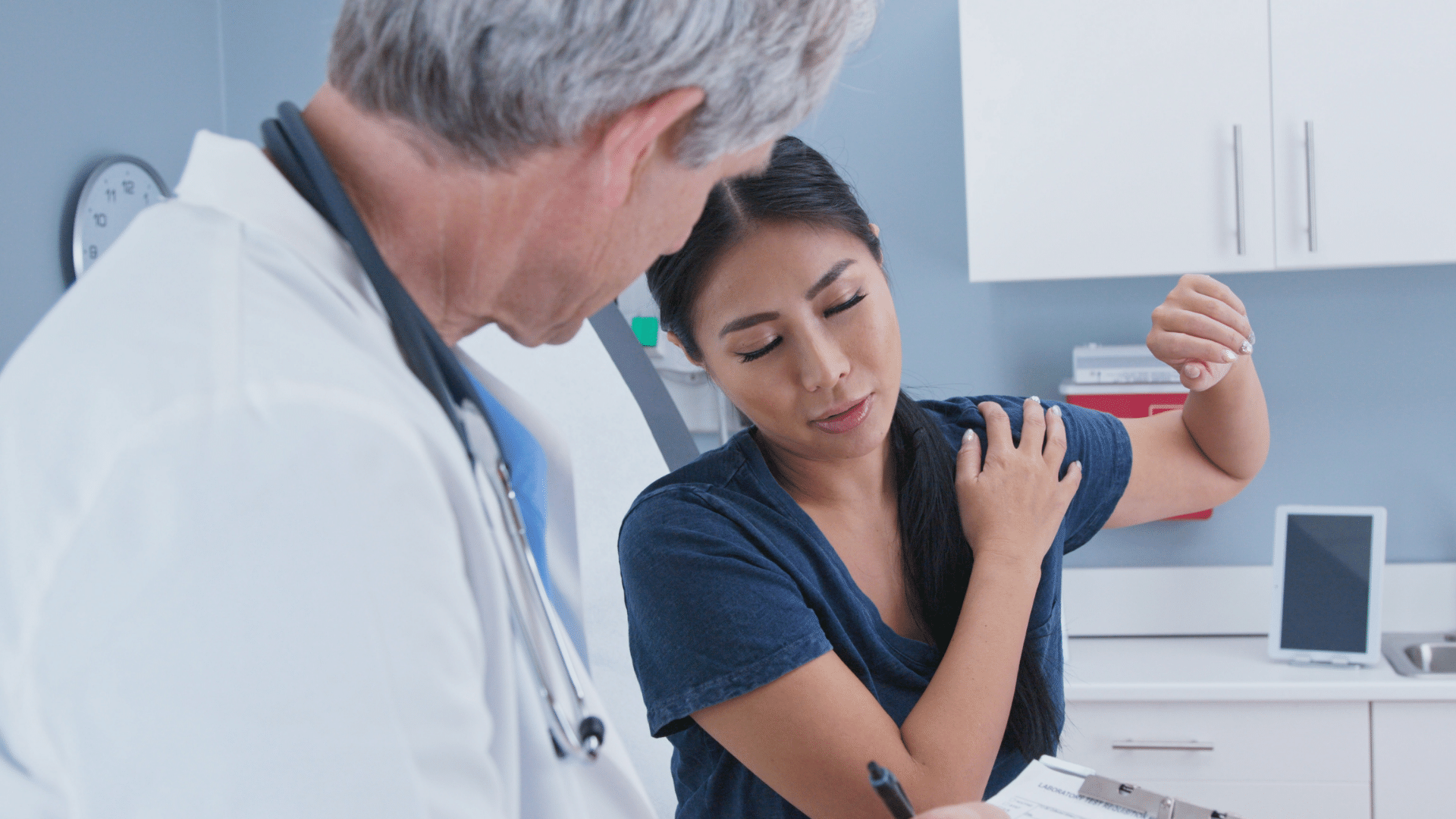 A doctor is examining a patient 's arm in a hospital.