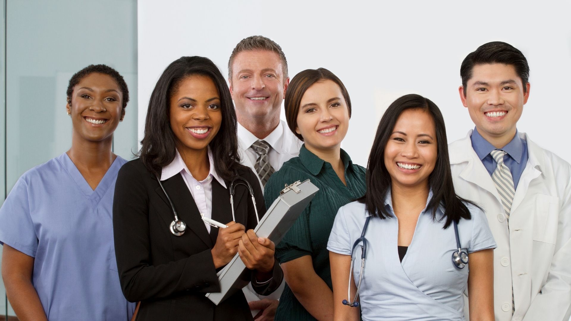 A group of doctors and nurses are posing for a picture together.