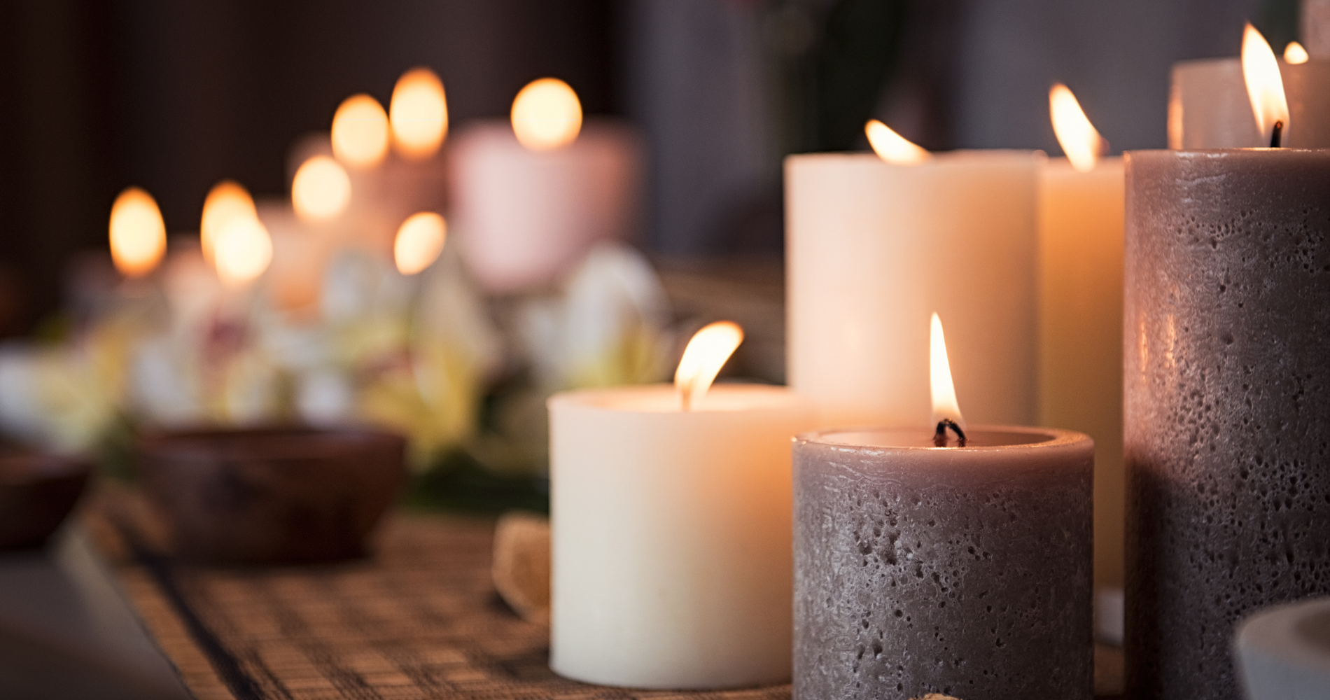 A group of lit candles sitting on top of a wooden table.