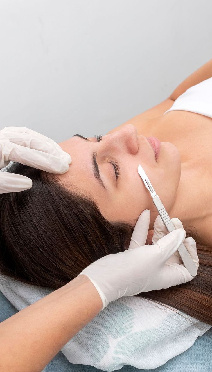 A woman is getting a botox injection in her forehead.