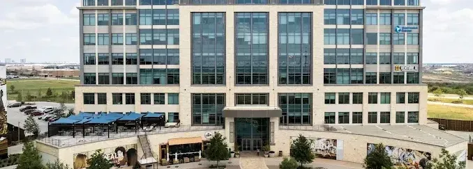 A large building with a lot of windows and trees in front of it. The Ali Team Office