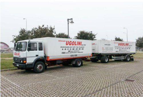 due camion parcheggiato sulla strada scritto su UGOLINI-IVECO 145-17 R