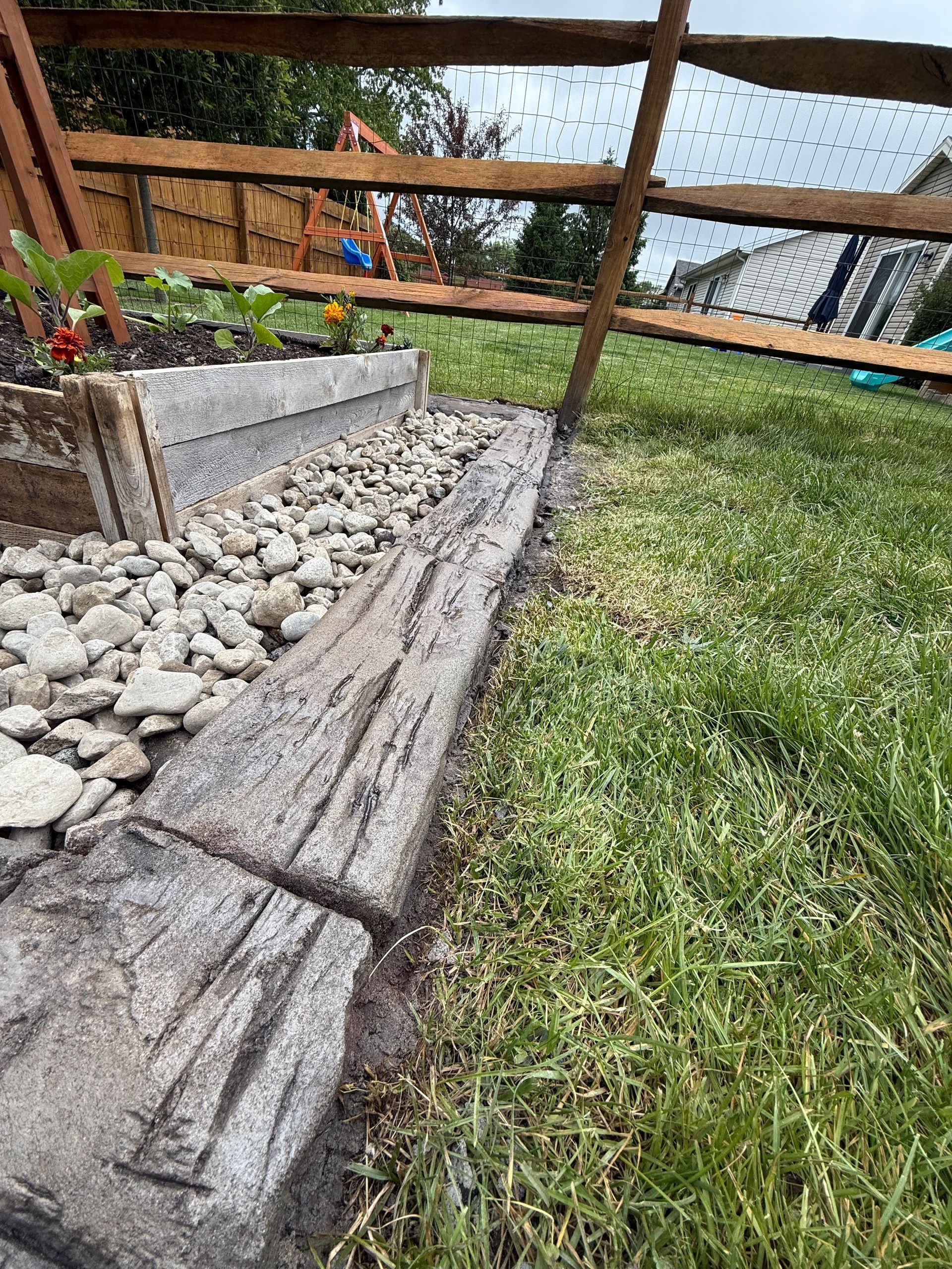 A large lawn with a tree in the middle of it in front of a house.