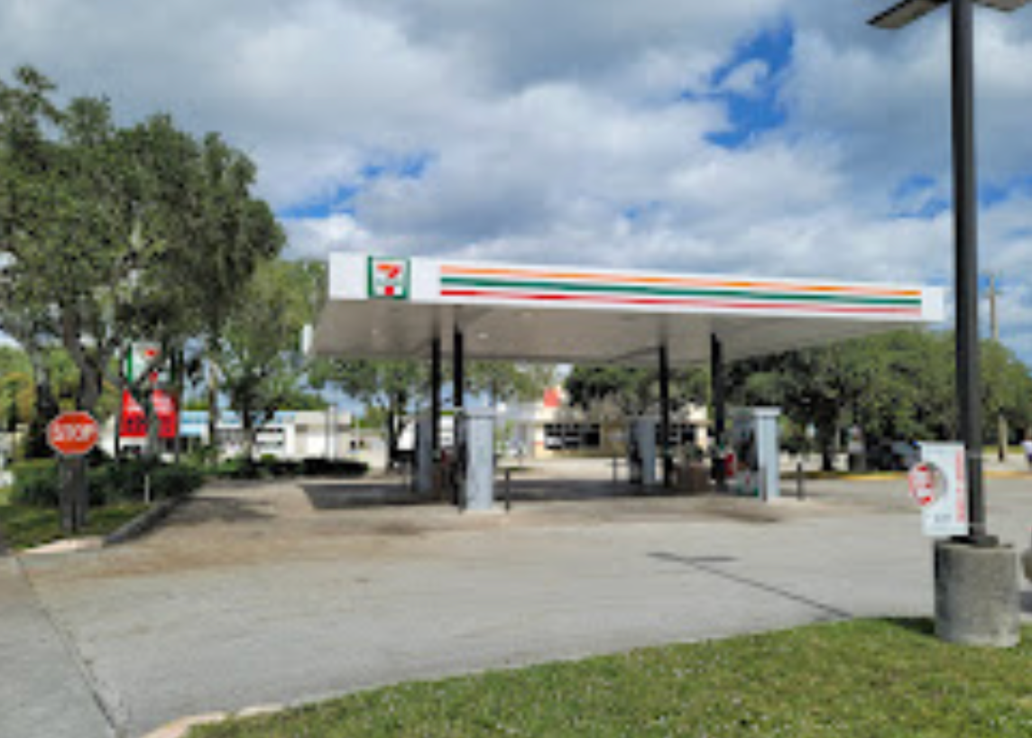 A 7 eleven gas station with a stop sign in front of it.